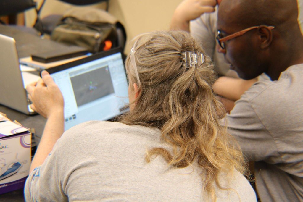 An instructor and student in front of a screen.