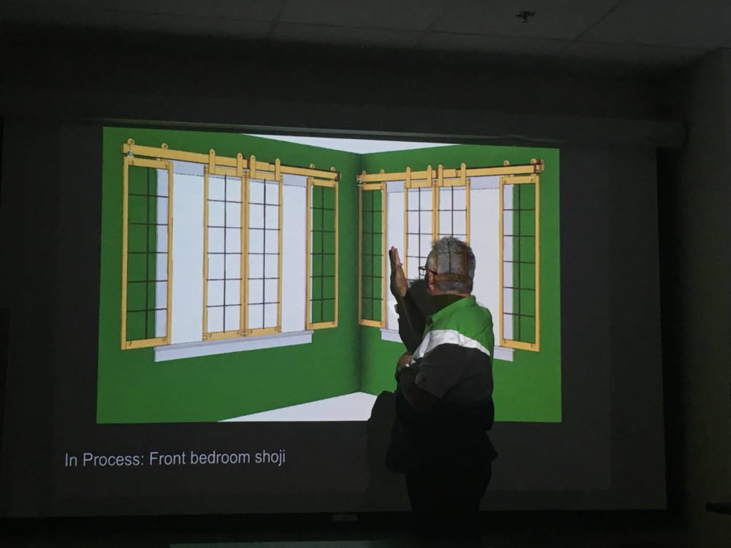 Michael McDonald showing slides of hanging screens over windows